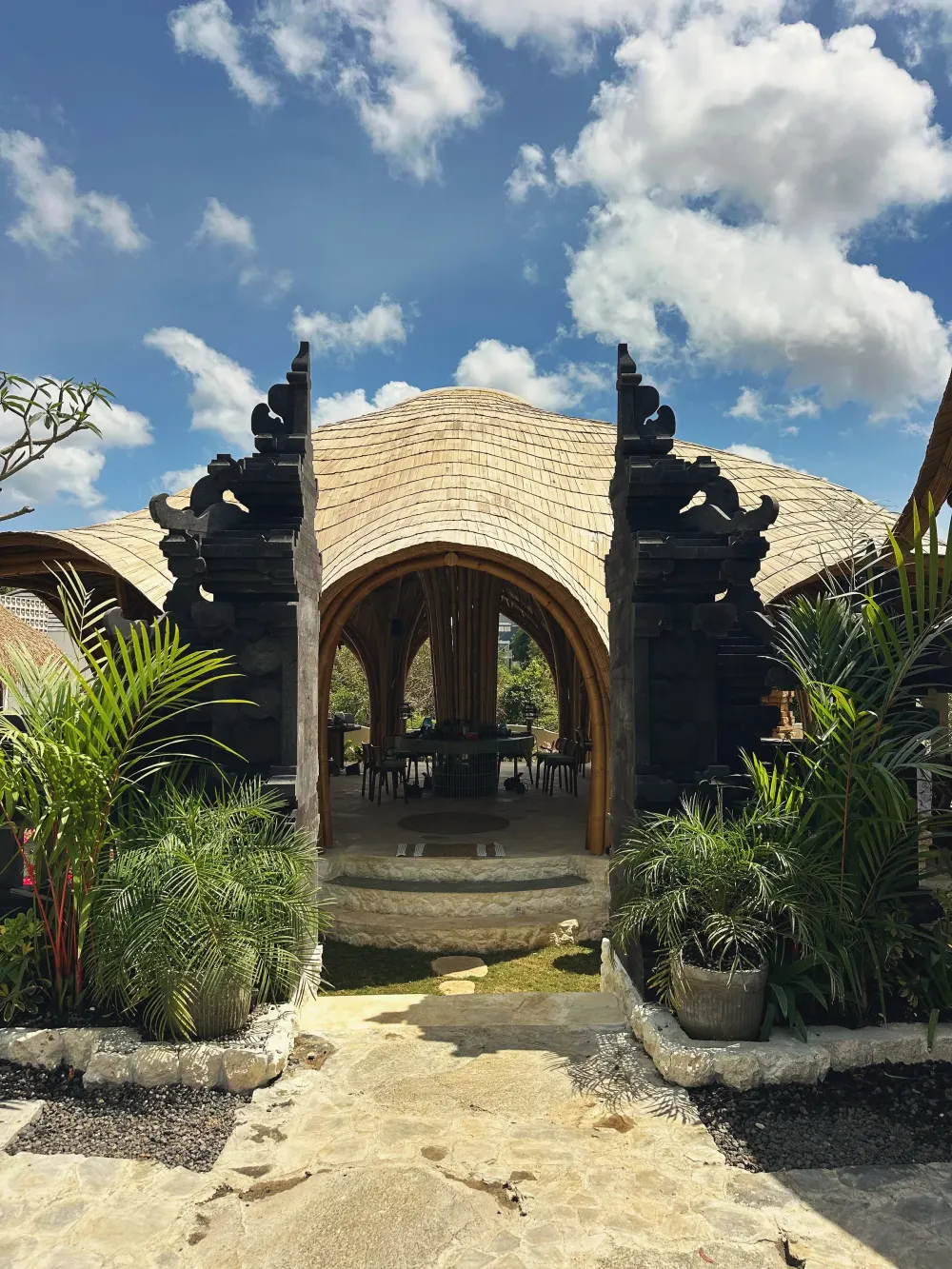 The carved stone candi gate of Bali Jewelry House opening onto its bamboo main house in Uluwatu